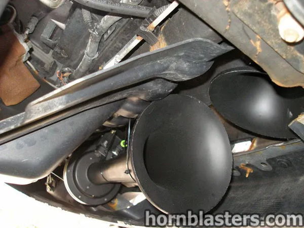 Underbody close-up of black Nathan AirChime K3 horn bells mounted near the frame on Jerry's Silverado, install photo 6