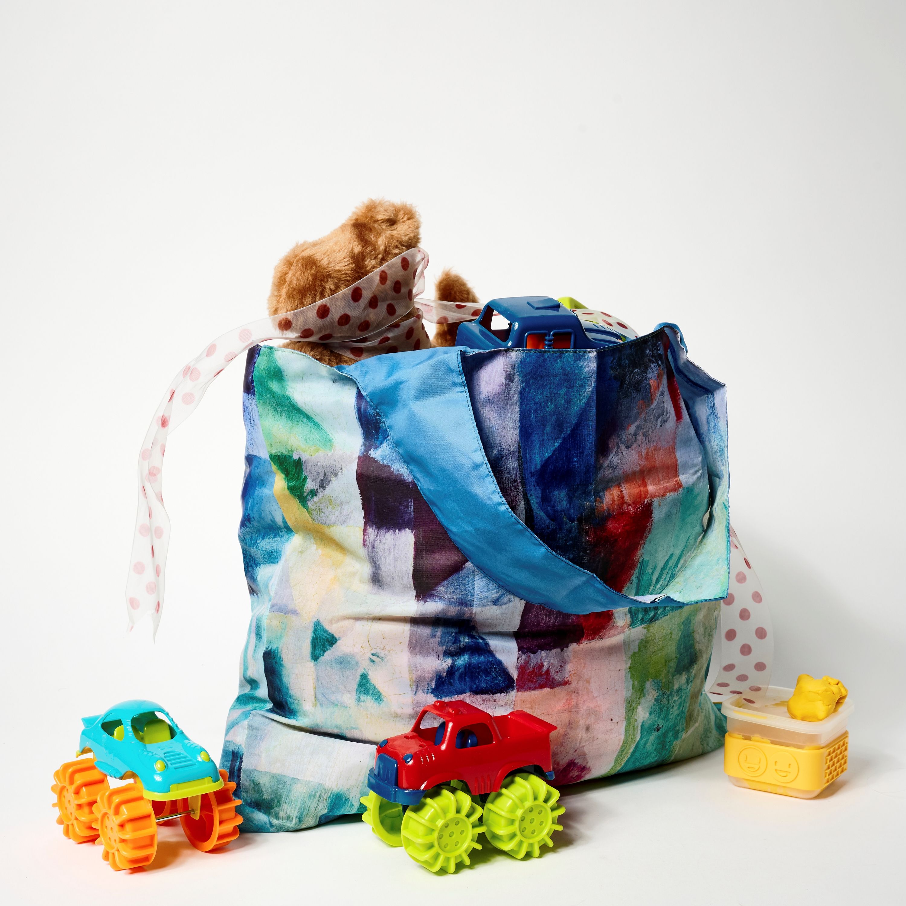 A colorful bag filled with toys and a stuffed animal.