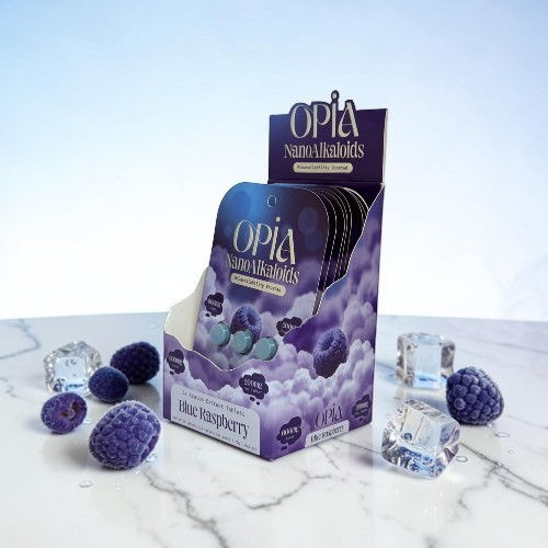Display of Opia beauty sponges with crystal accents on a marble surface.