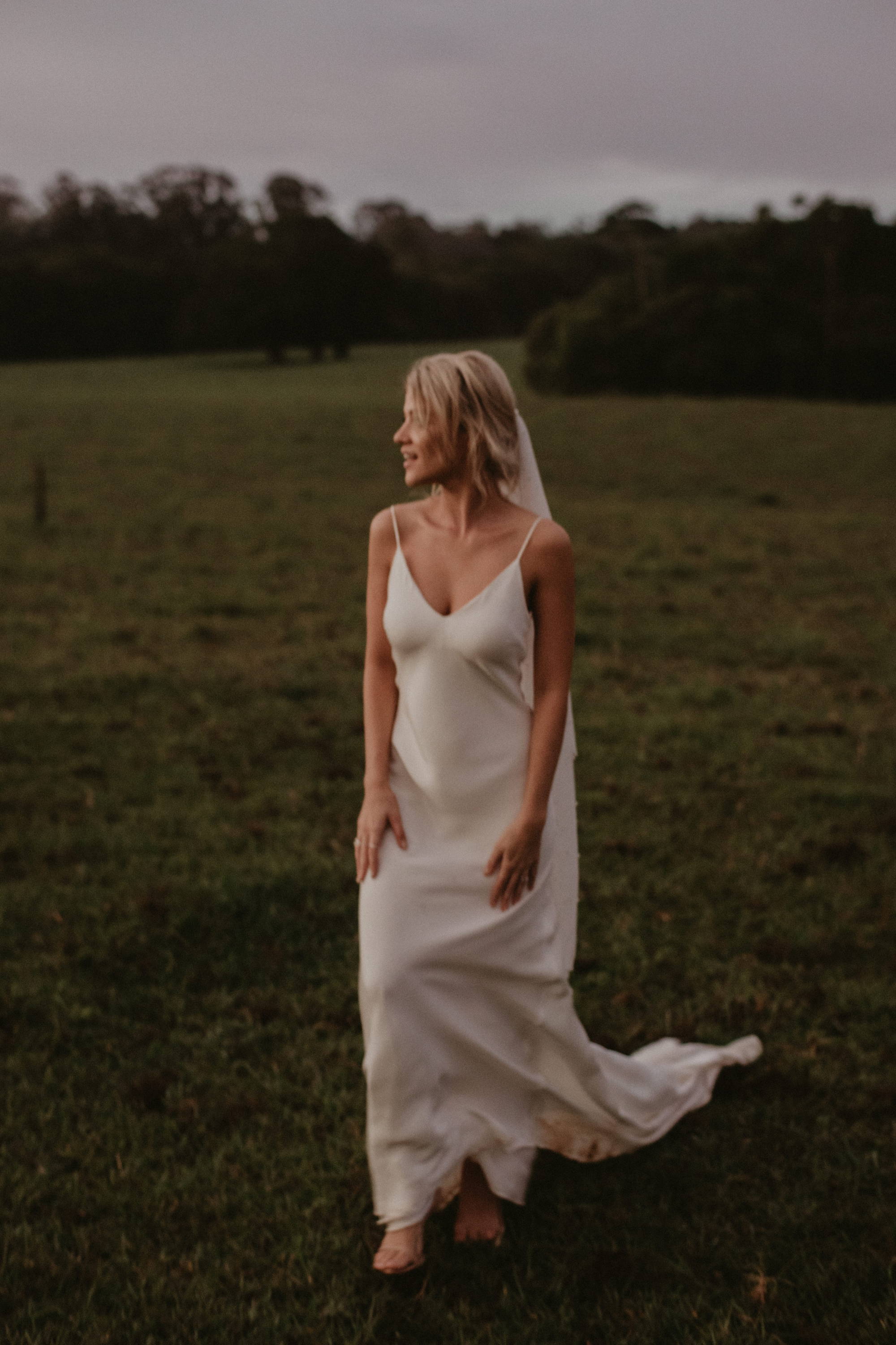 Grace Loves Lace bride wearing the Summer gown in a grass field