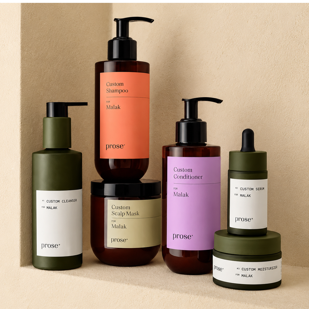 Five bottles of hair care products on a neutral background.