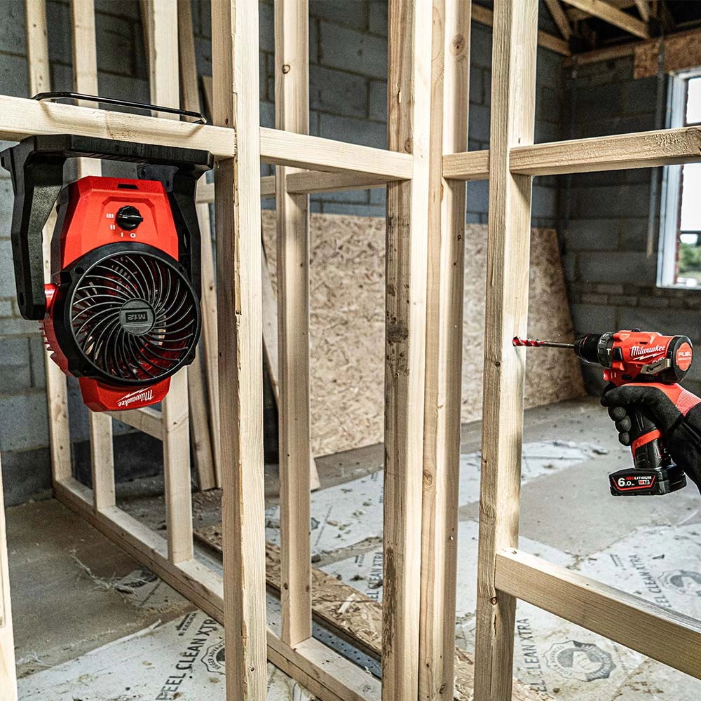 A construction site with a blower and a power tool on wooden framing.