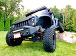 Front quarter dark blue Jeep Wrangler Rubicon on boulder FOX shocks angry grille LED light bar Donn's 2014 Rubicon Conductor's Special 244 Nightmare Edition gallery photo 2