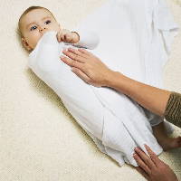 Baby being wrapped in swaddle