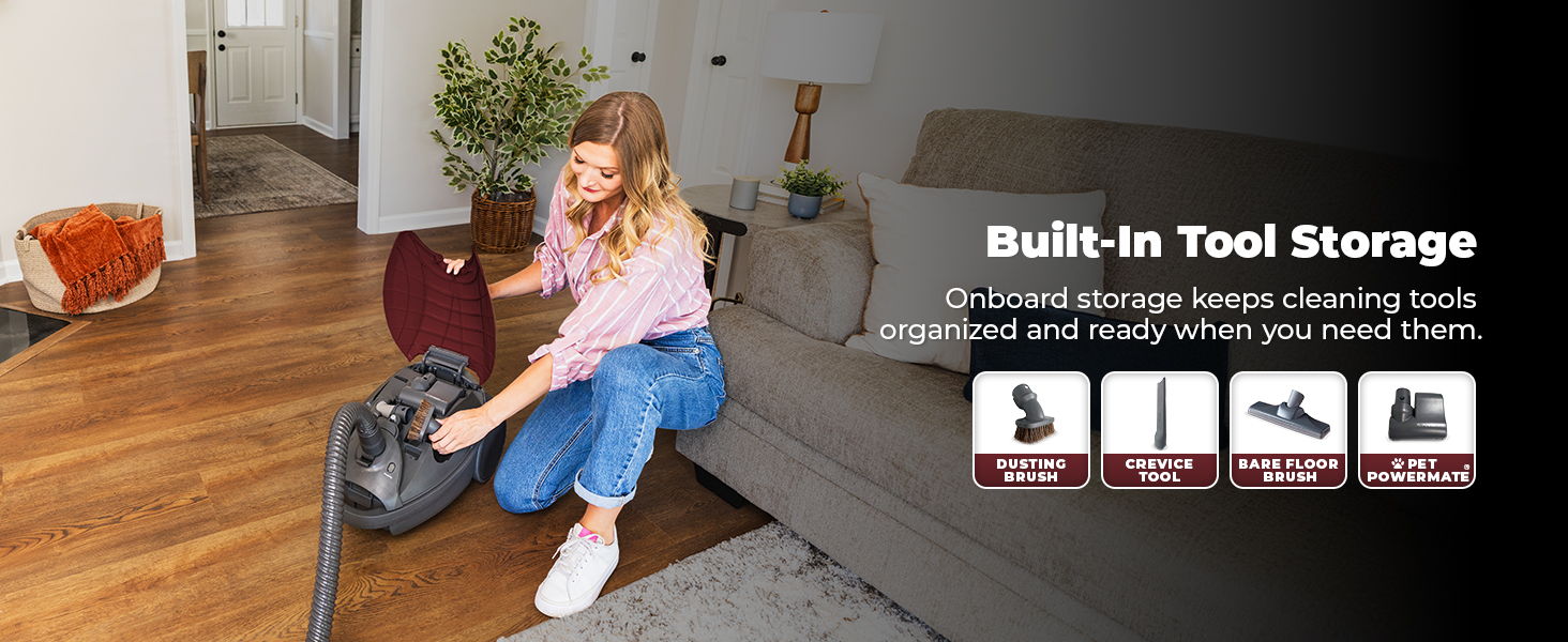 Woman using a vacuum cleaner with built-in tool storage in a modern living room.