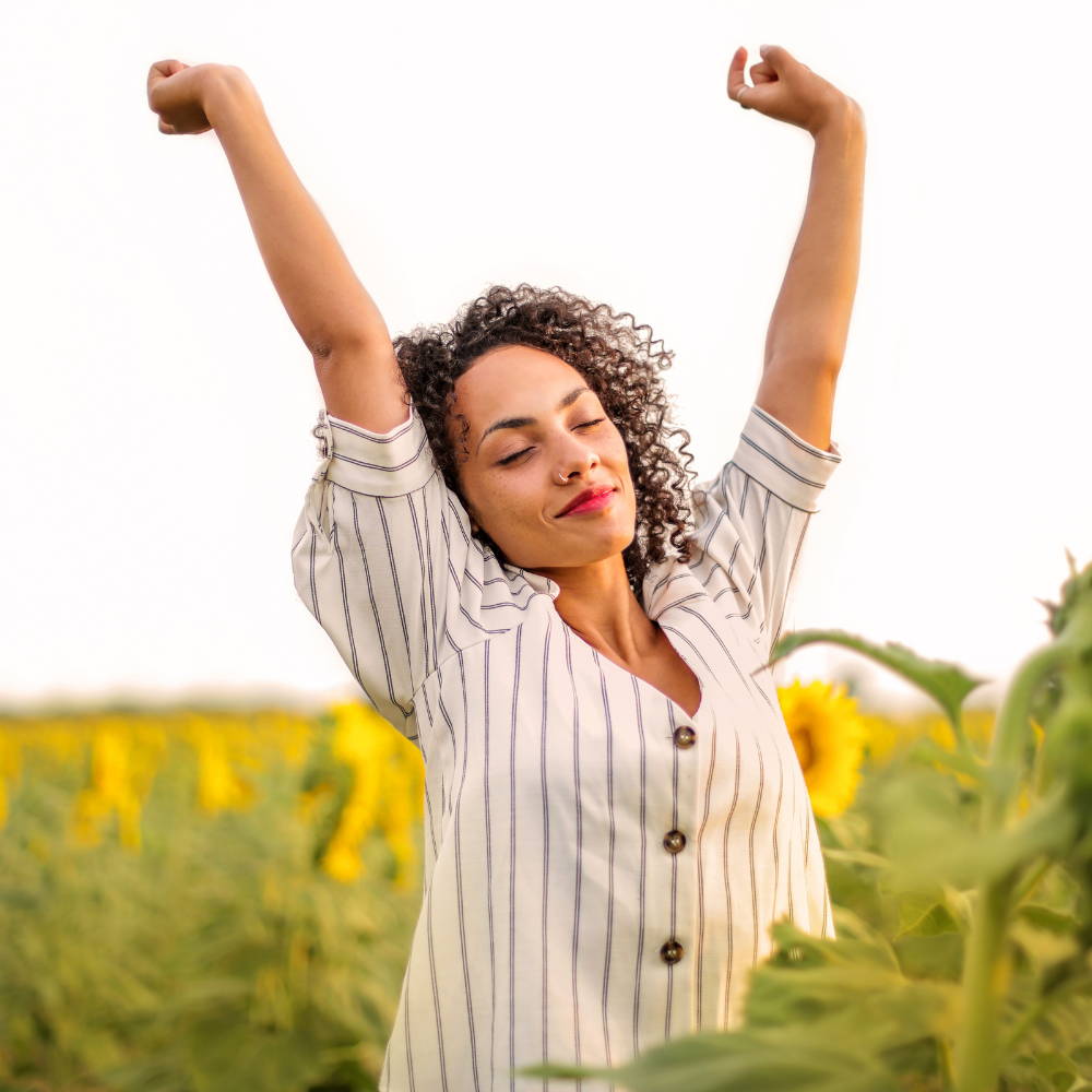 Woman stretching in a field of sunflower