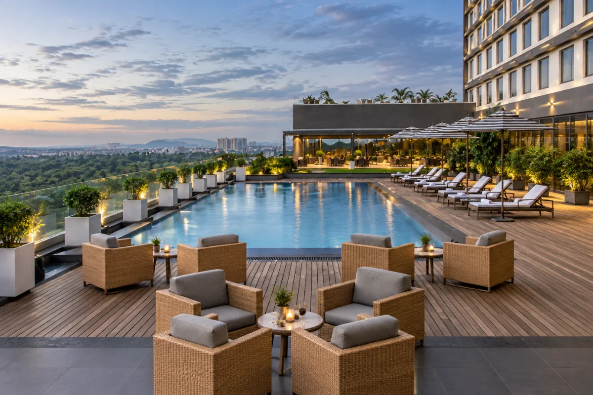 Modern hotel rooftop pool deck with commercial outdoor lounge chairs, dining furniture, umbrellas, and guest seating zones