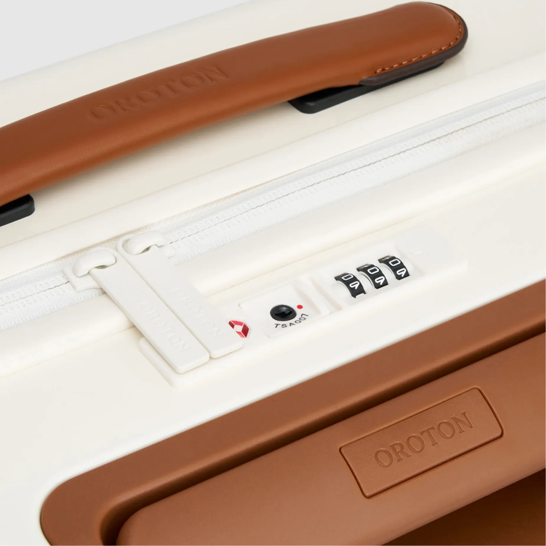 Brown handle and combination lock on a white suitcase.