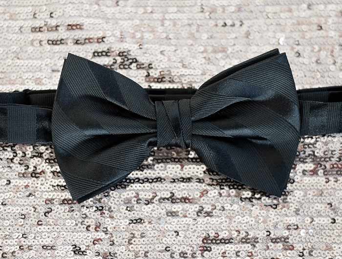 Black tone on tone striped bow tie on a sequin background