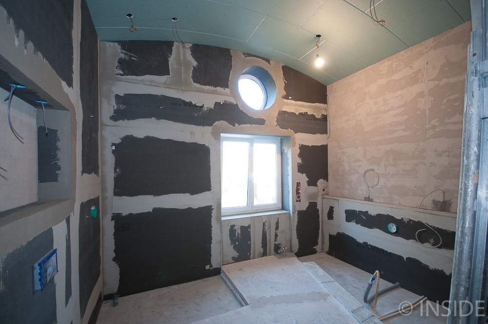 Interior of a room under construction with unfinished walls and a window.