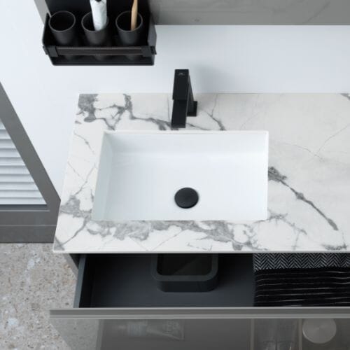 Modern sink with black faucet on marble countertop.