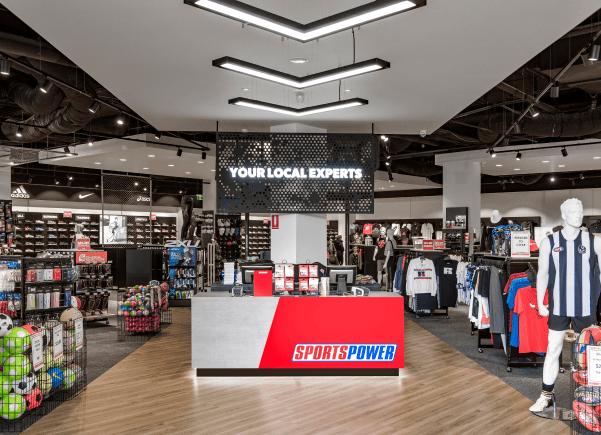 Retail store interior with merchandise displays and a prominent sign.