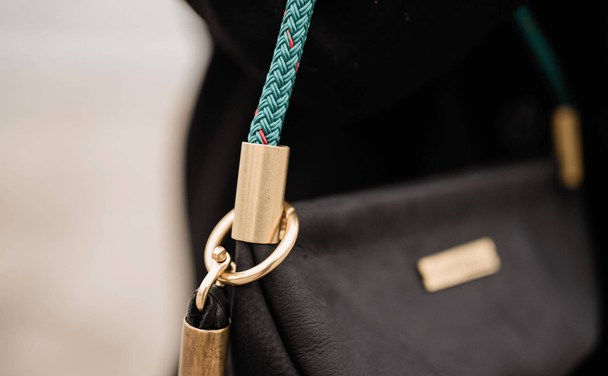 close up of black leather clam shell bag with brass hardware