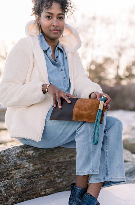 woman holding brown clutch