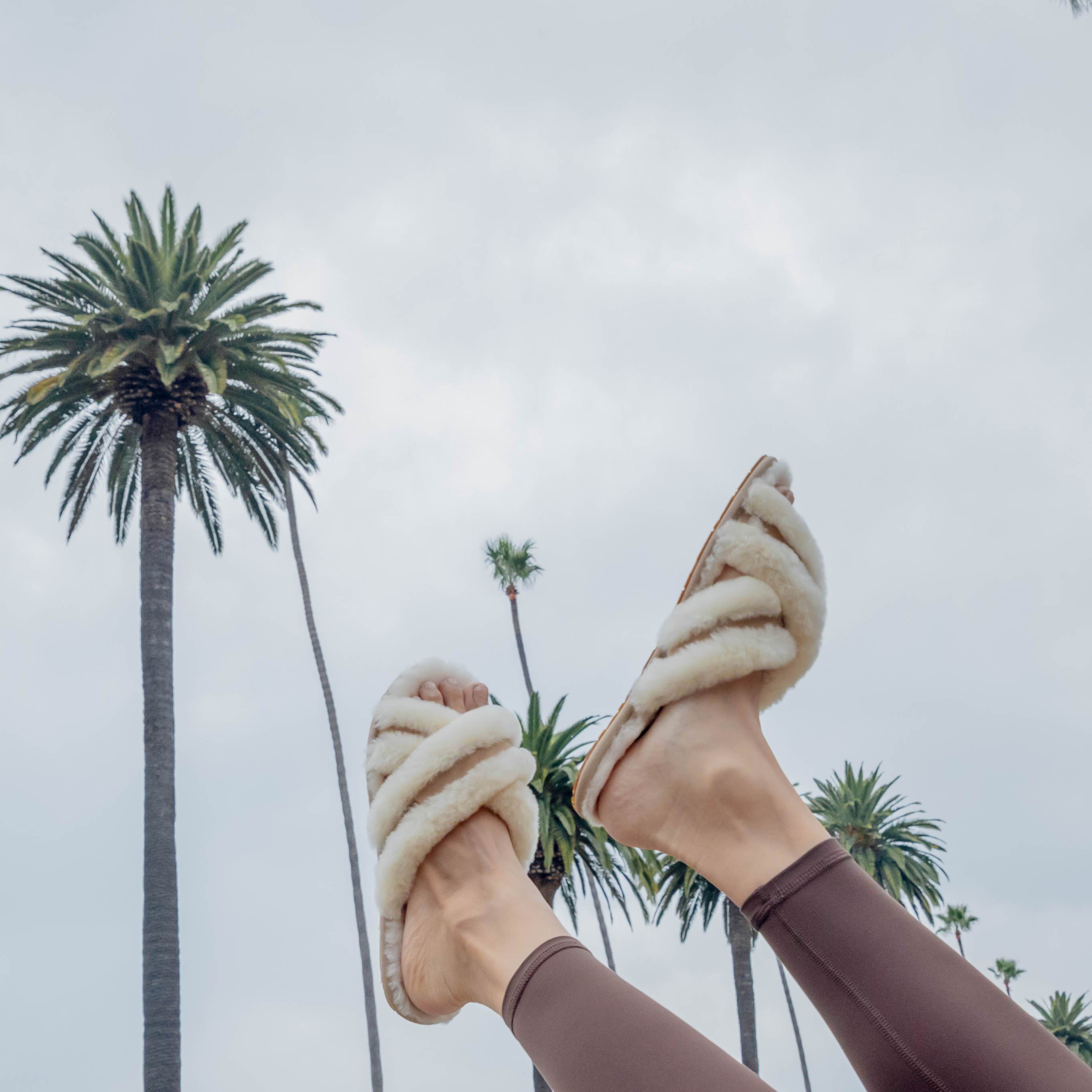 cream ugg slippers on female model's feet
