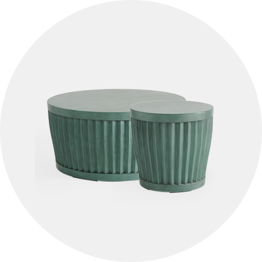 Two green decorative tables, one round and one cylindrical, with vertical grooves.