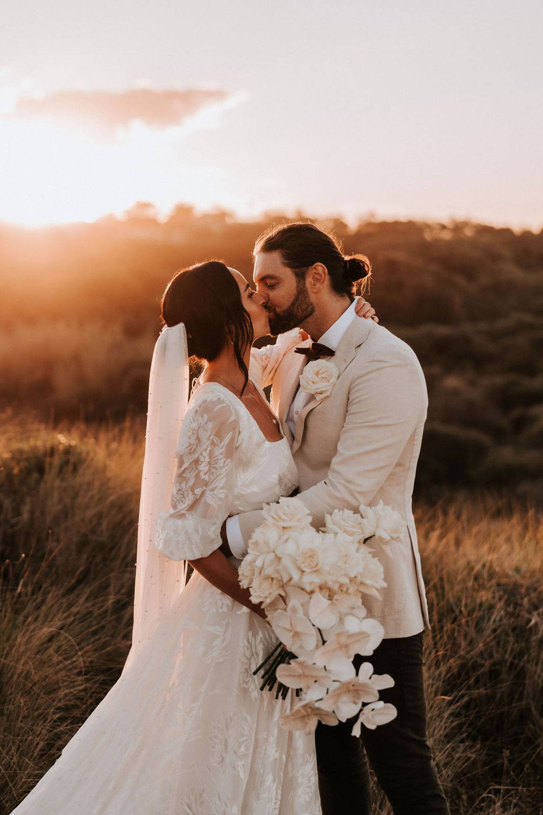 Bride and Groom kissing. Bride holding bouquet