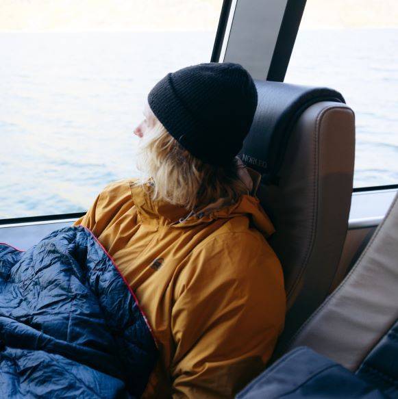Person sitting on a ferry with a blanket