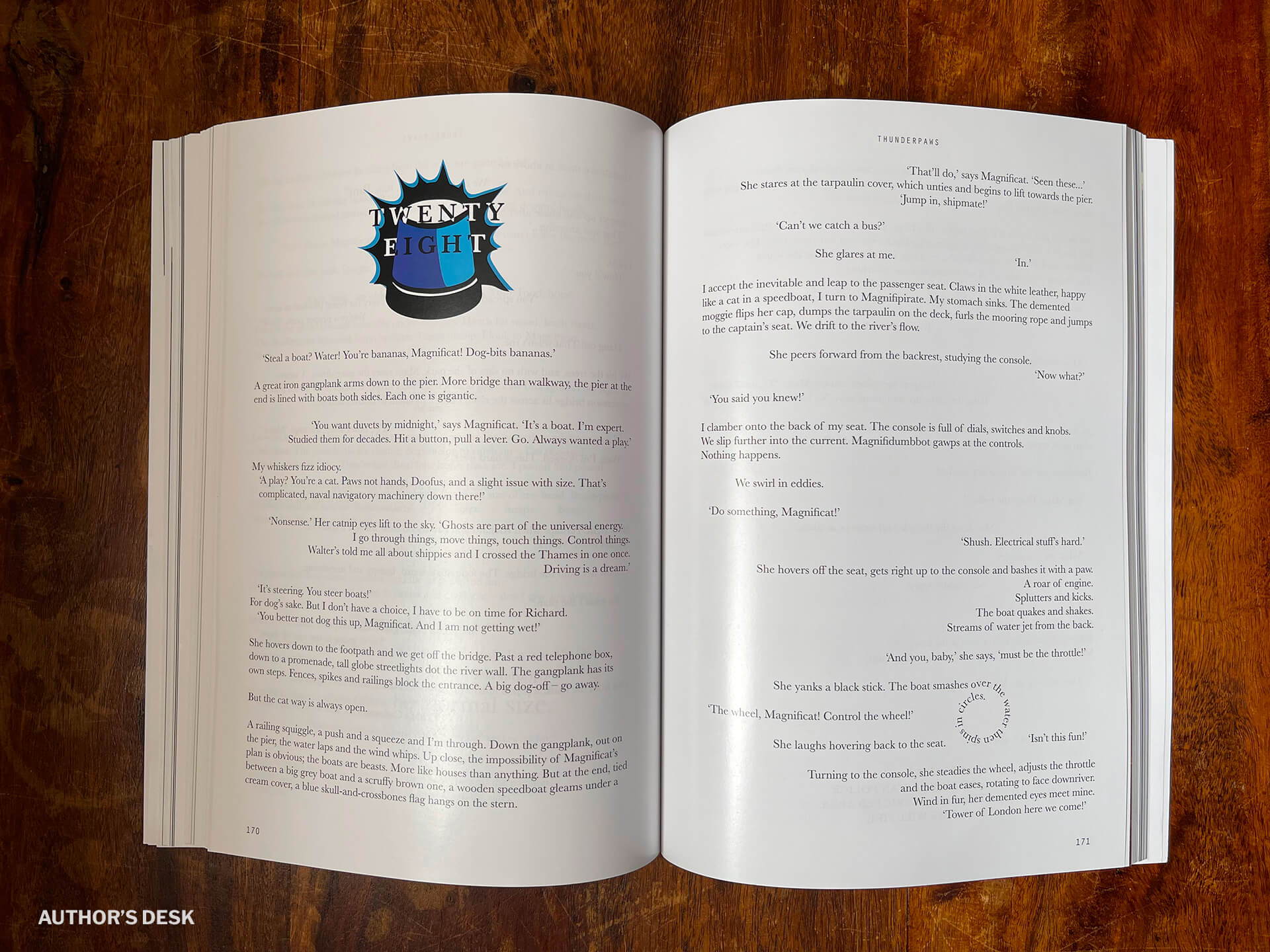 A picture of the open print book showing the start of chapter 28. A flashing blue light is the chapter motif. Again, the text below and opposite illustrates the book's custom text formatting on each page