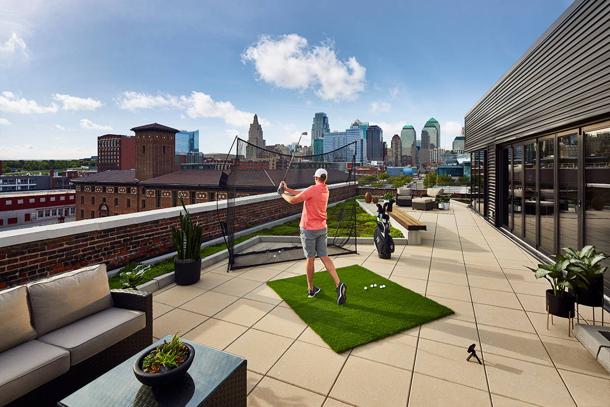 A golfer on a rooftop with his home golf setup using the Garmin Approach R10