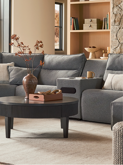 Curated living room with mixed textures, grey reclining seating, and decorative accessories.
