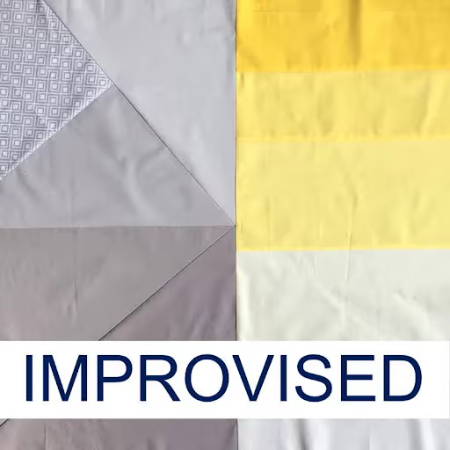 An improvised baby quilt top with grey and yellow fabrics
