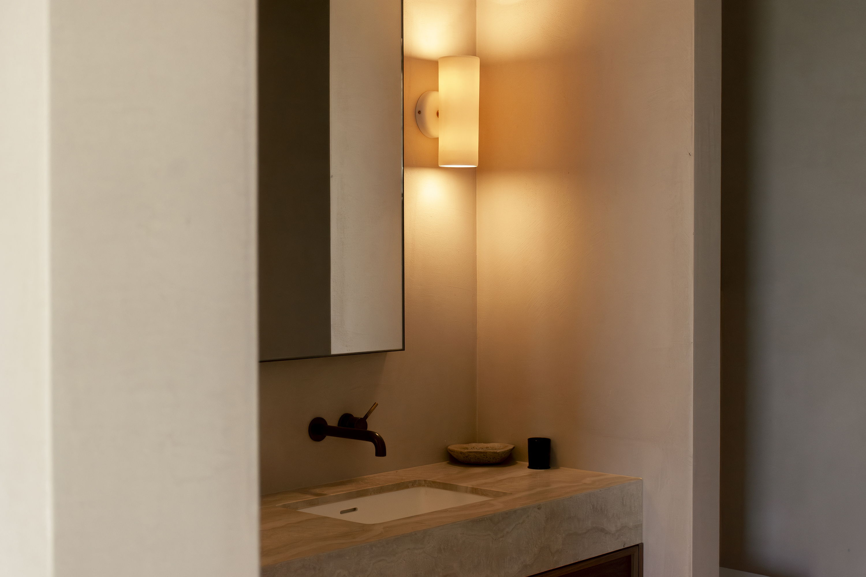 Modern bathroom with a sink, lamp, and neutral color tones.