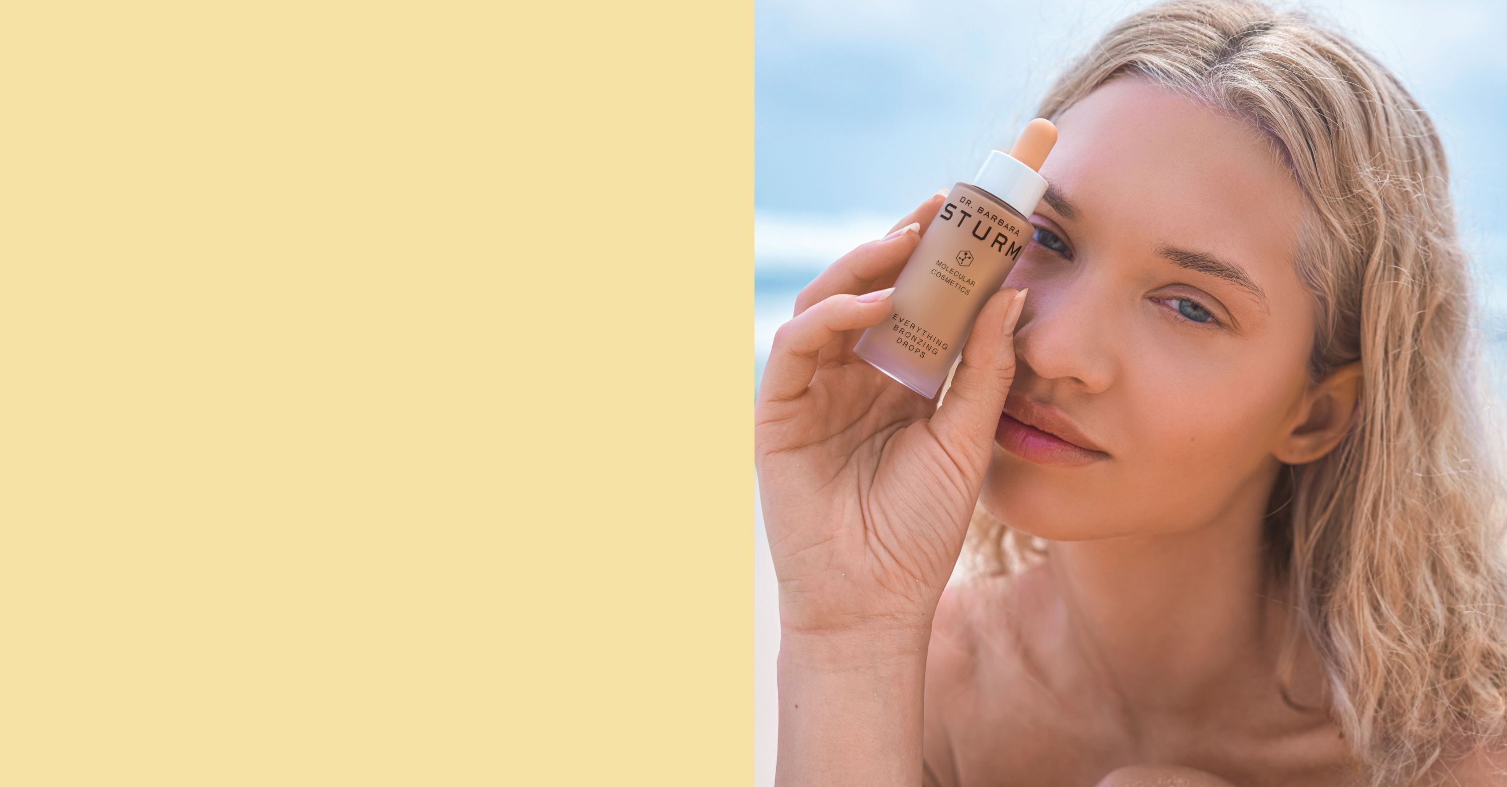 Young woman holding a beauty product near her eye on a beach.