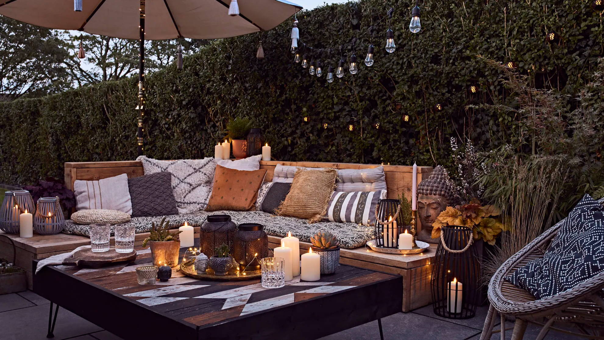 Alfresco table top with TruGlow candles, garden lanterns and festoons illuminated