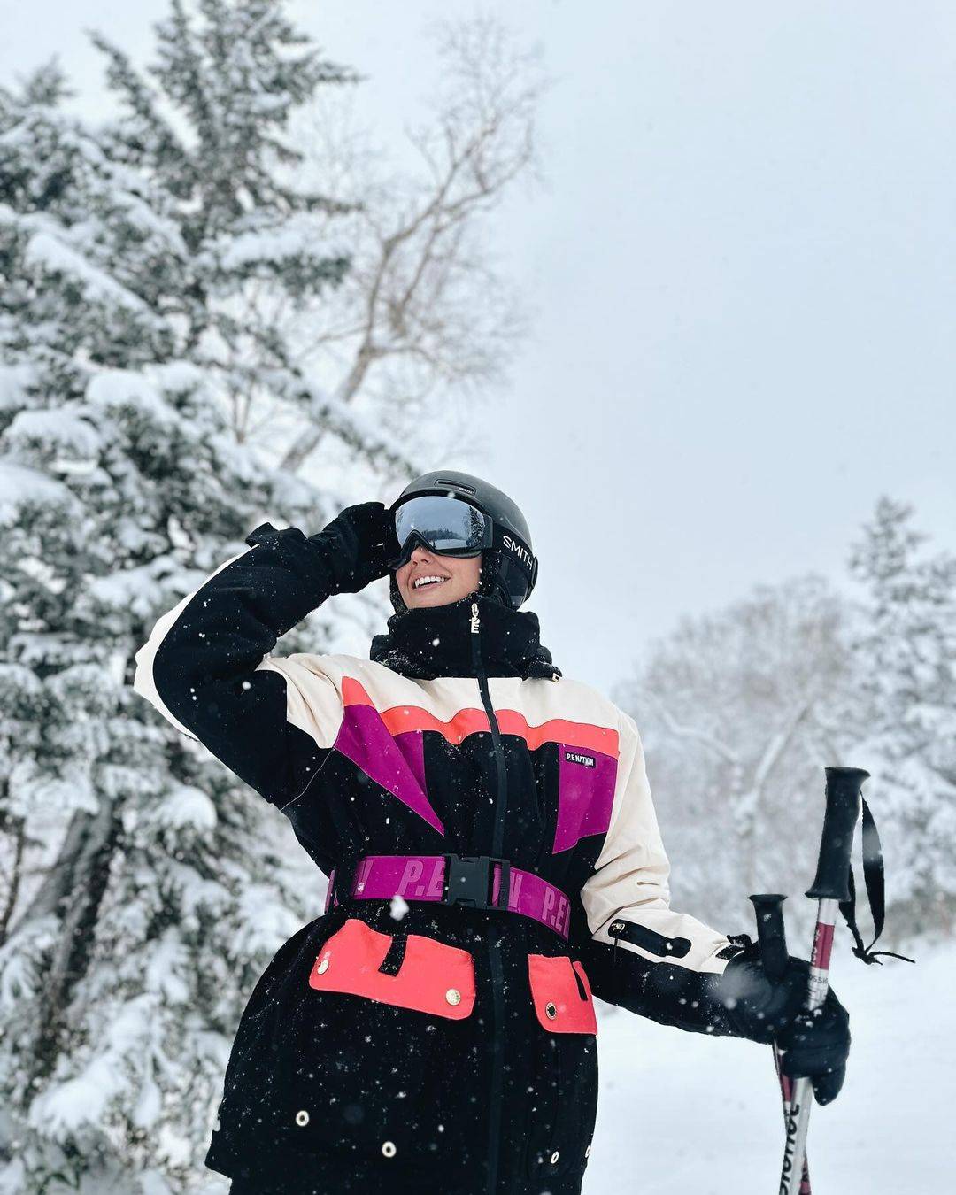 A woman skiing as it snows outside