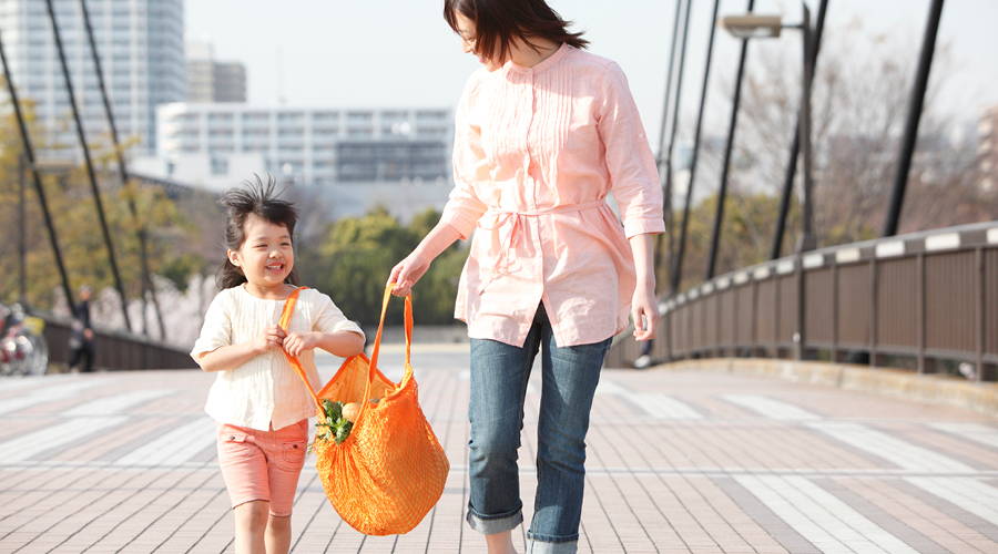 mom and daughter walking with reusable bag