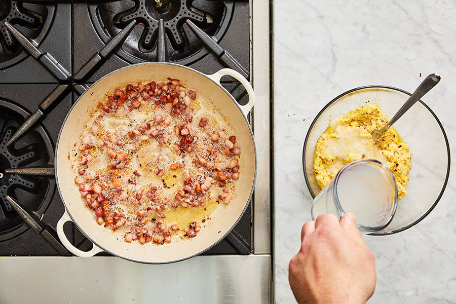 Pancetta continuing to cook, pasta water added to egg mixture to create a sauce.