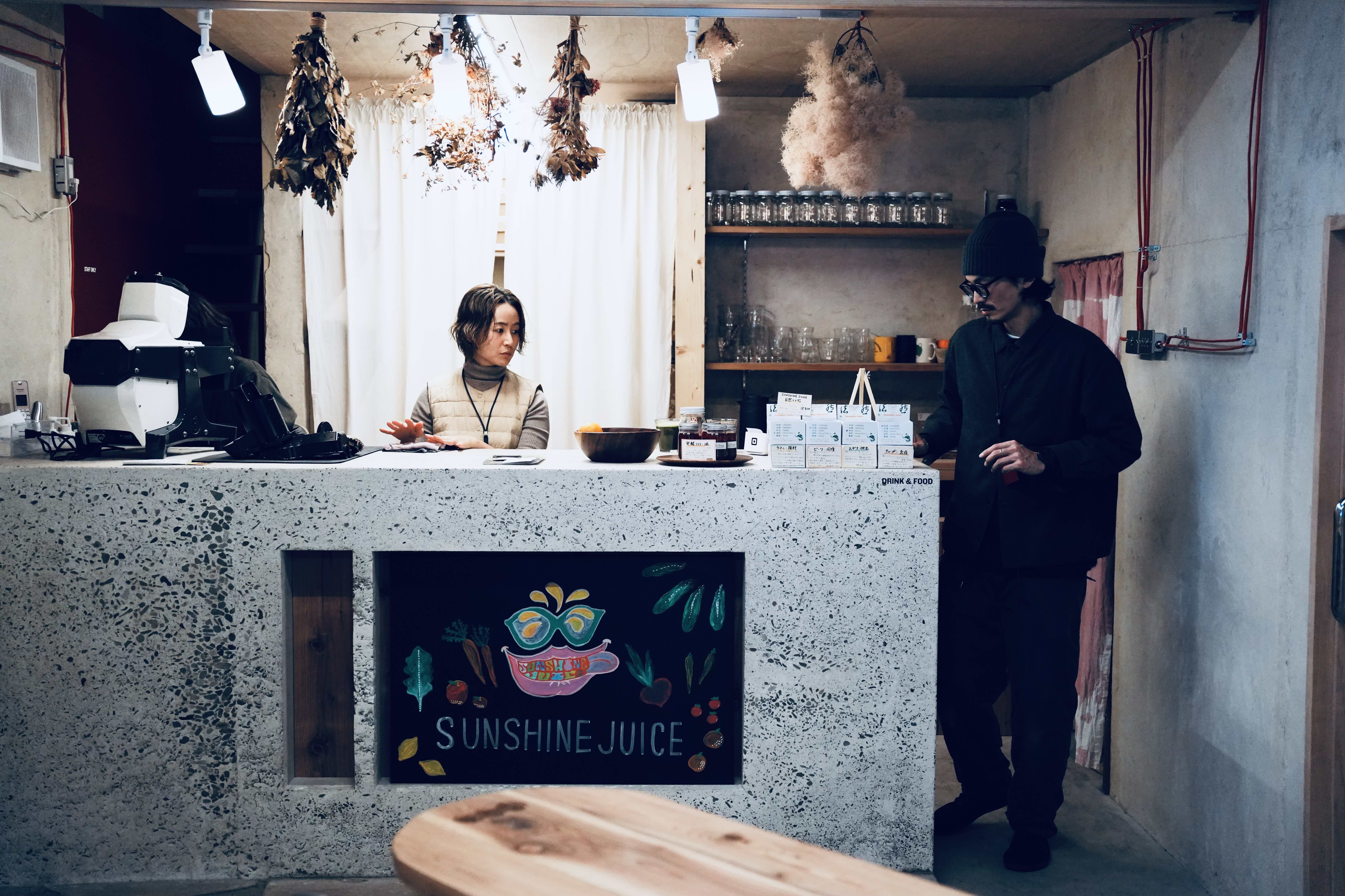 A café scene with a counter, two people, and decorative elements.