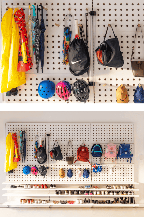 Storage wall with various bags, helmets, umbrellas, and raincoats organized neatly.