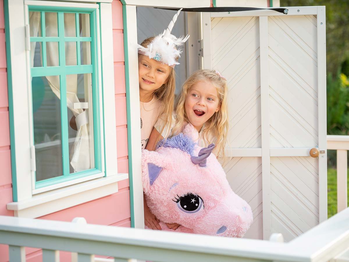 Kids looking out the door of Wooden Playhouse Unicorn by WholeWoodPlayhouses