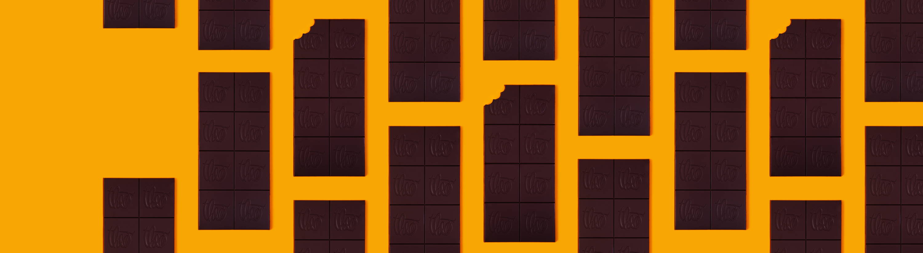 Unwrapped Theo Chocolate bars on orange background