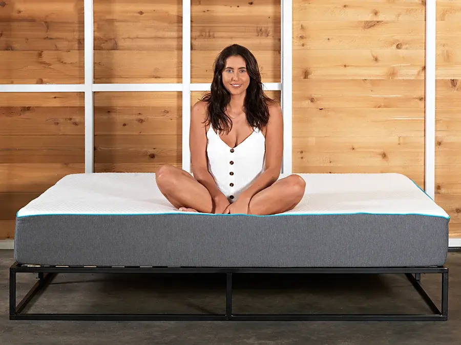 A woman staring at the camera, on a Hybrid Mattress from Zeek.com.au