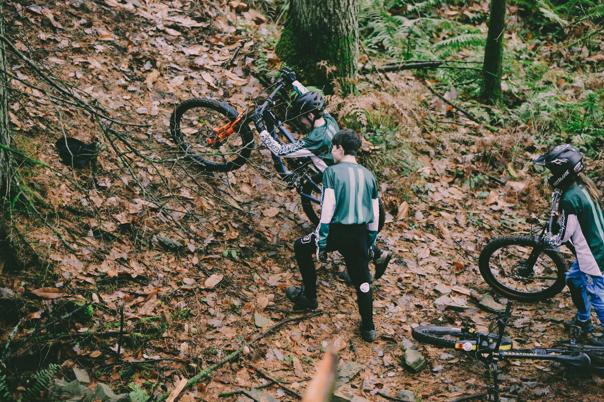 Team riders climbing steep bank