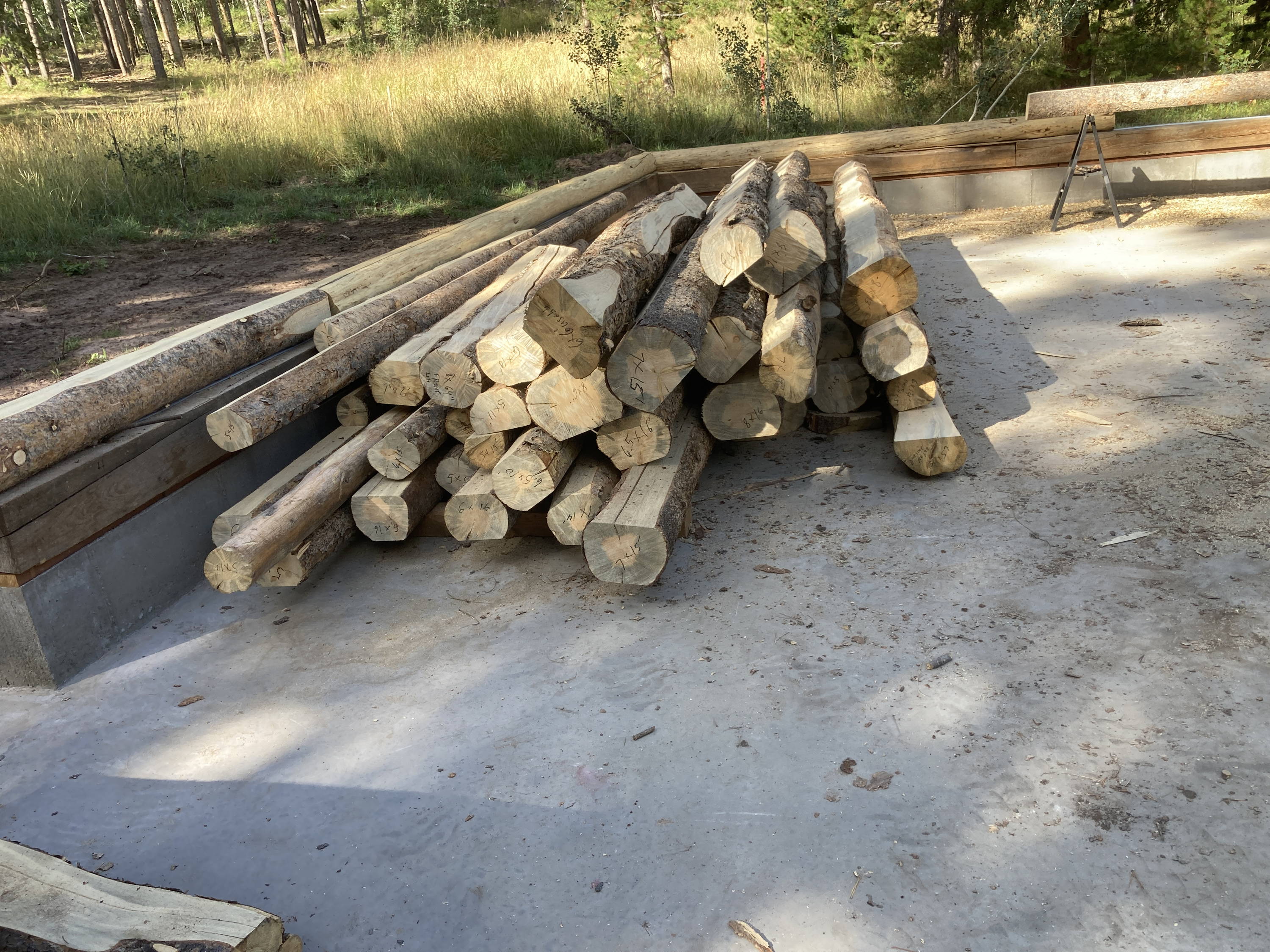 A pile of treated logs ready to be assembled
