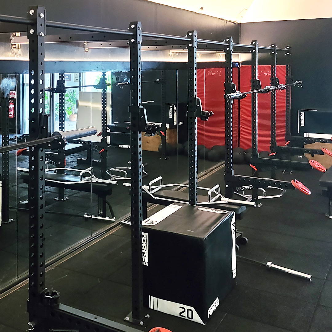 Well-organized commercial gym with a dedicated powerlifting area featuring competition-grade benches and squat racks