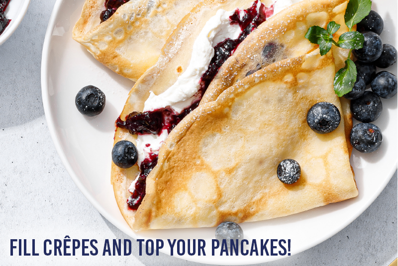Golden crêpes filled with cream and blueberry jam, topped with fresh blueberries and powdered sugar, with the text 
