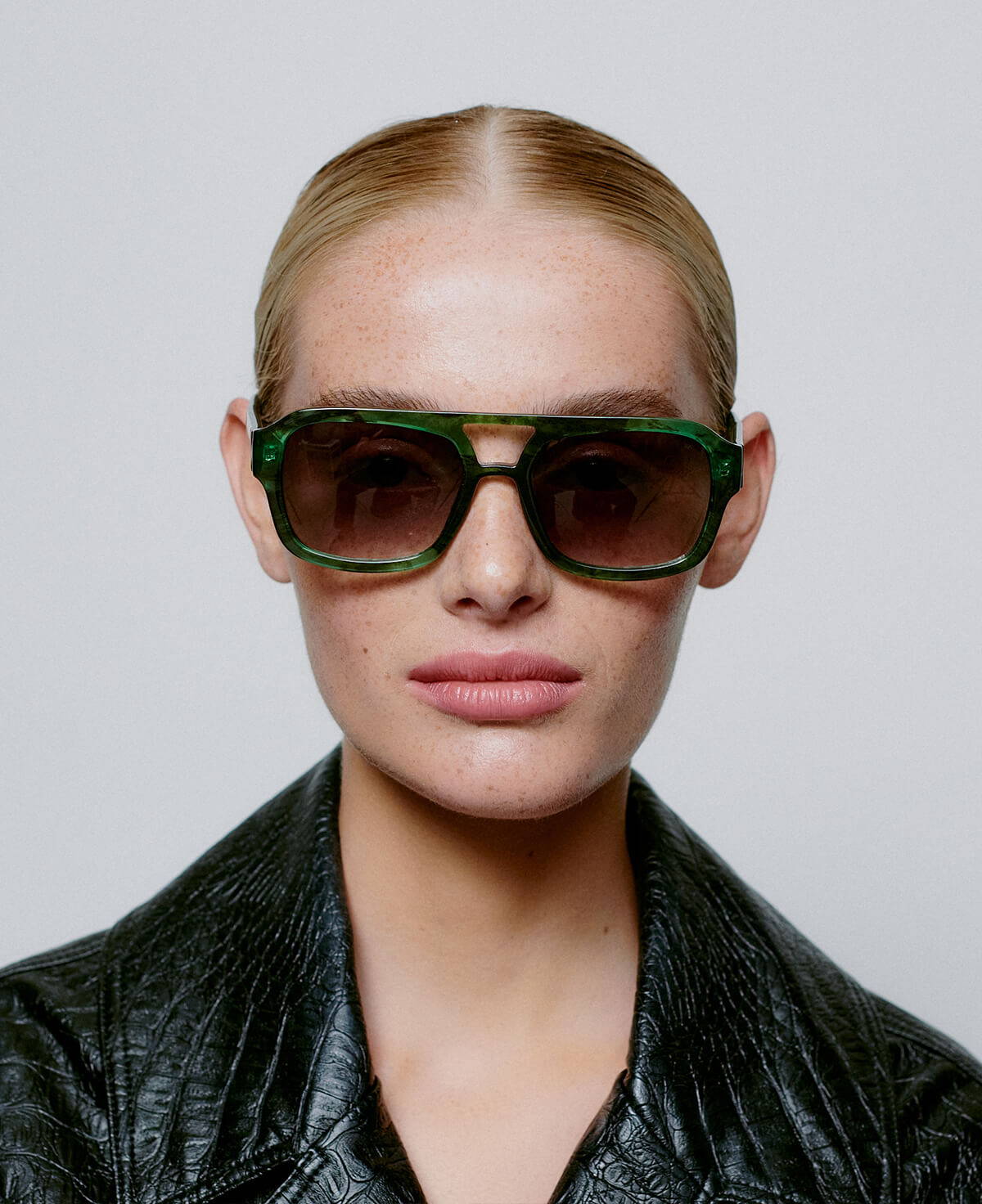 A picture of a model wearing the A.Kjaerbede  Kaya sunglasses in Green marble Transparent.