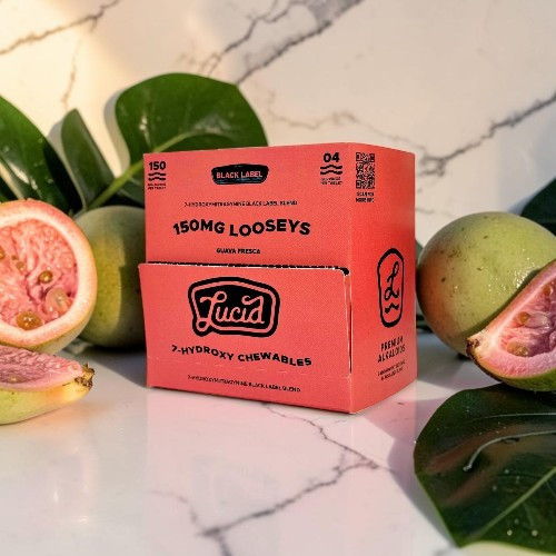 A pink box of Lucid flavored light paper with guava on a marble surface.