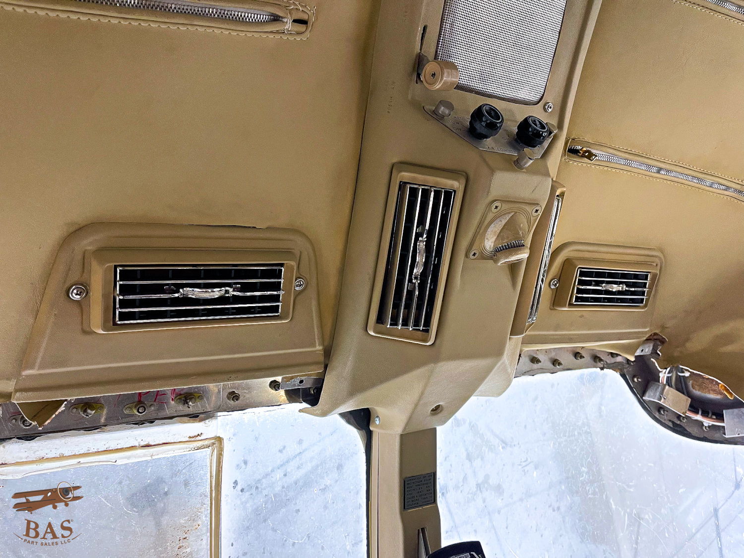 Interior view of a vehicle's ceiling with air vents and controls.