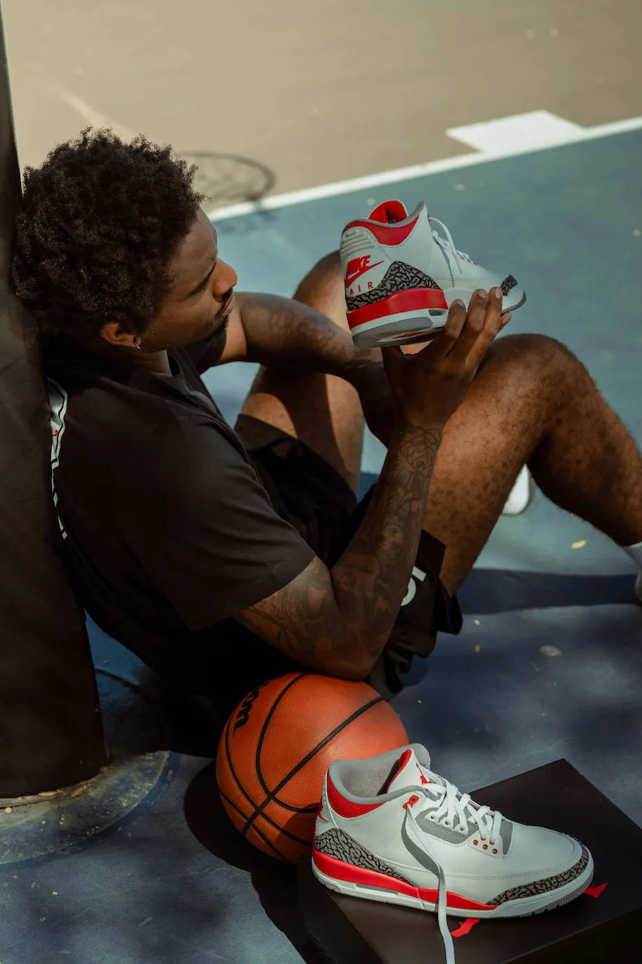 male model looking at the aj3 retro og fire red