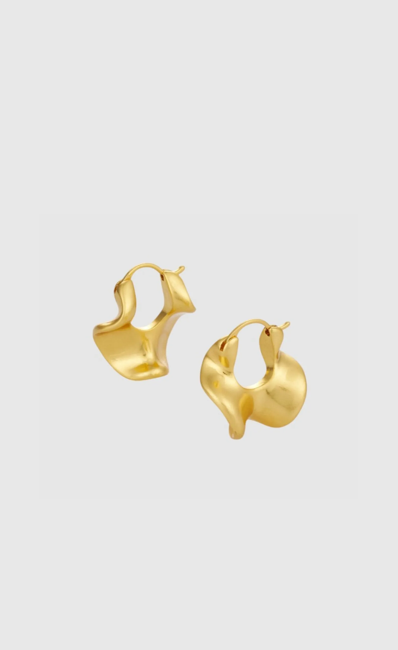 A pair of modern gold hoop earrings on a light background.