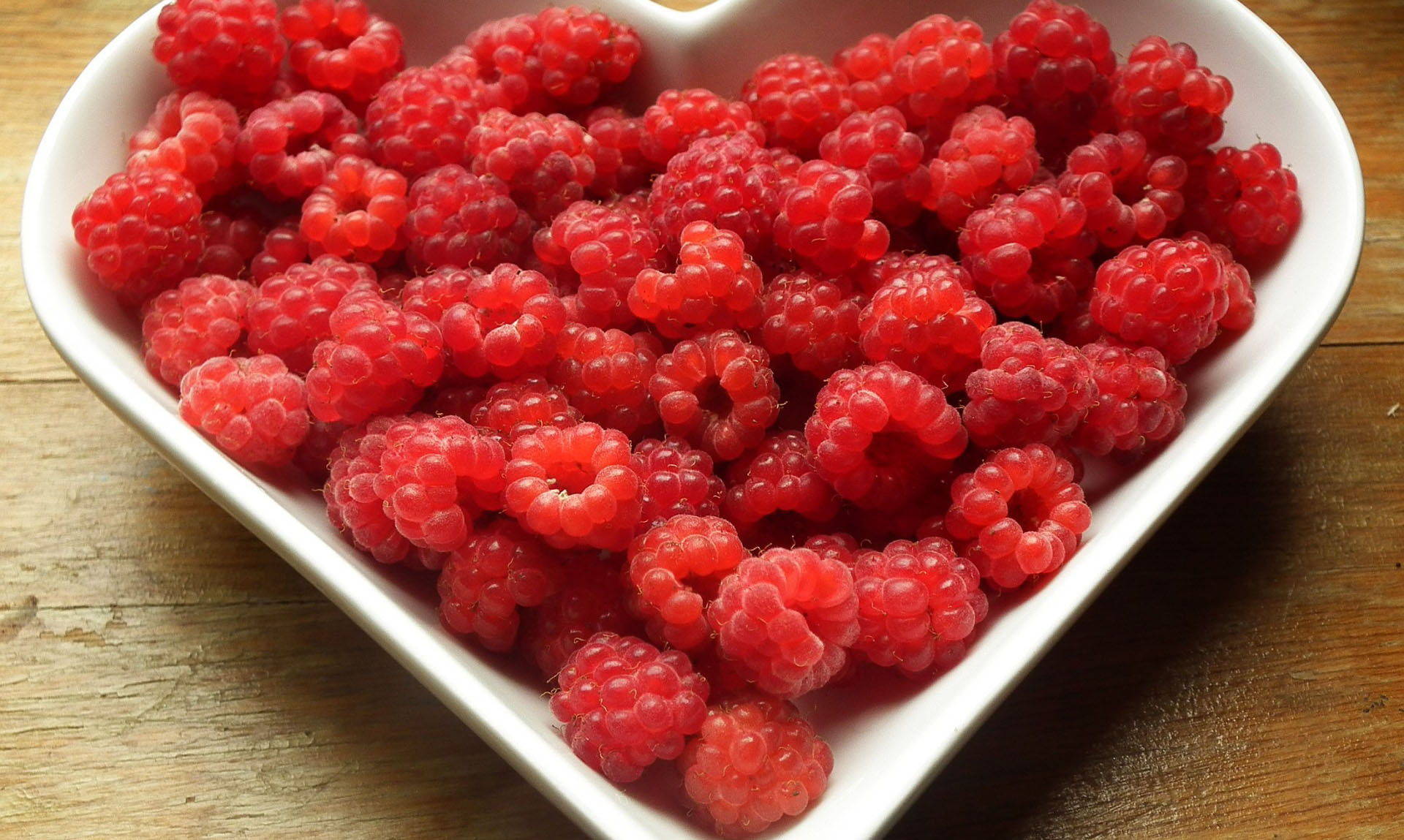 heart shaped bowl of raspberries