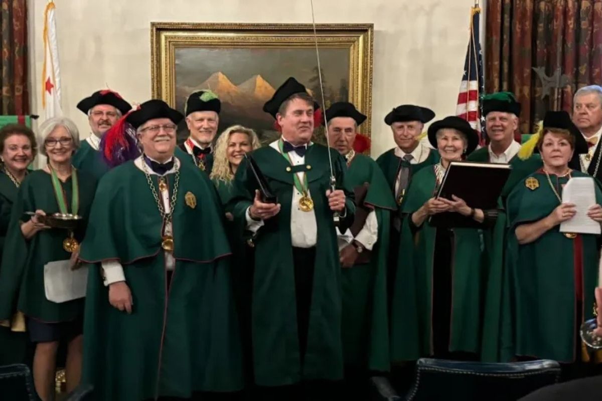 Group of people in green robes posing for a photo.