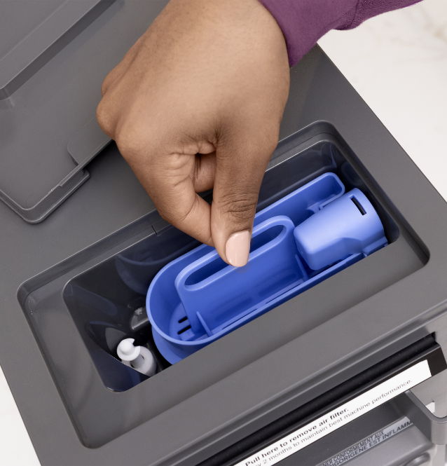 Hand removing a blue tool from a gray storage compartment.