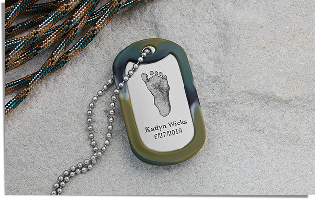 military dog tag engraved with a footprint, name, and birthdate